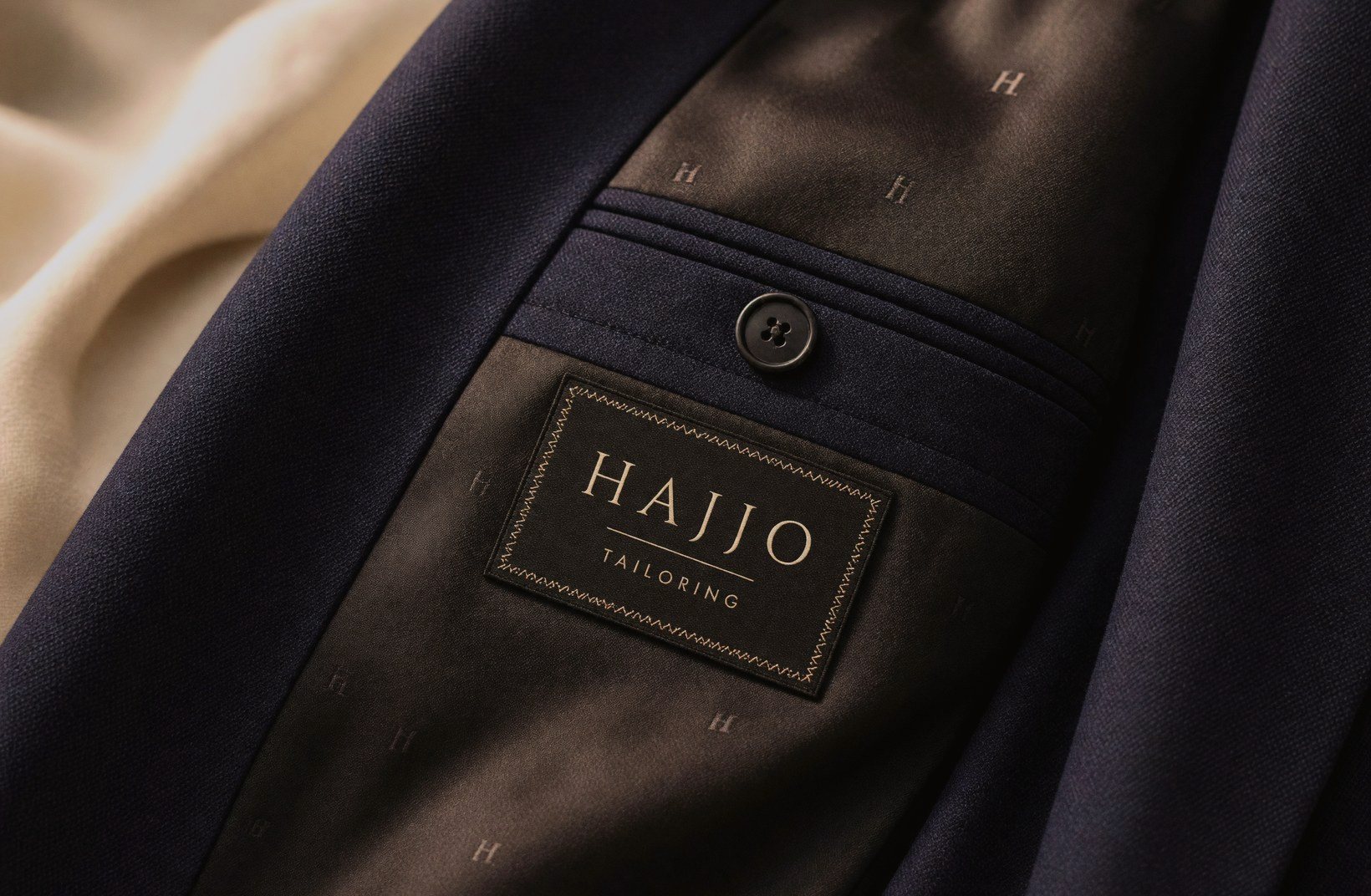 Inside of a navy jacket with the Hajjo Tailoring woven label